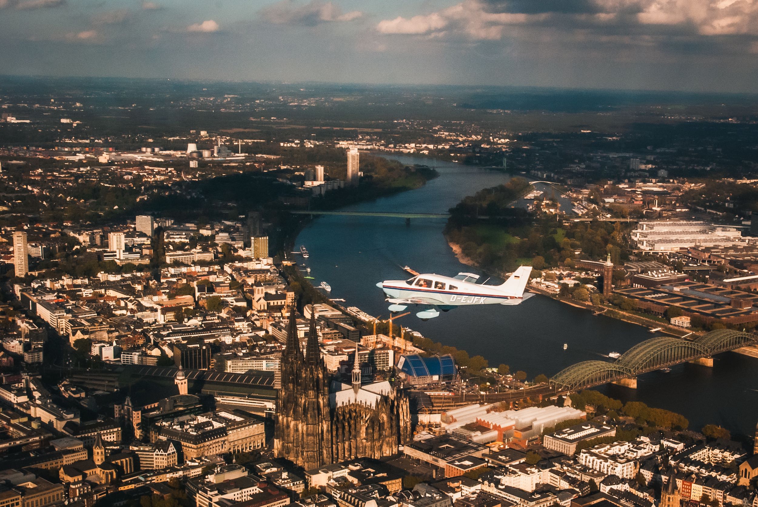 Vereinsflugzeug über Kölner Innenstand vor Dom