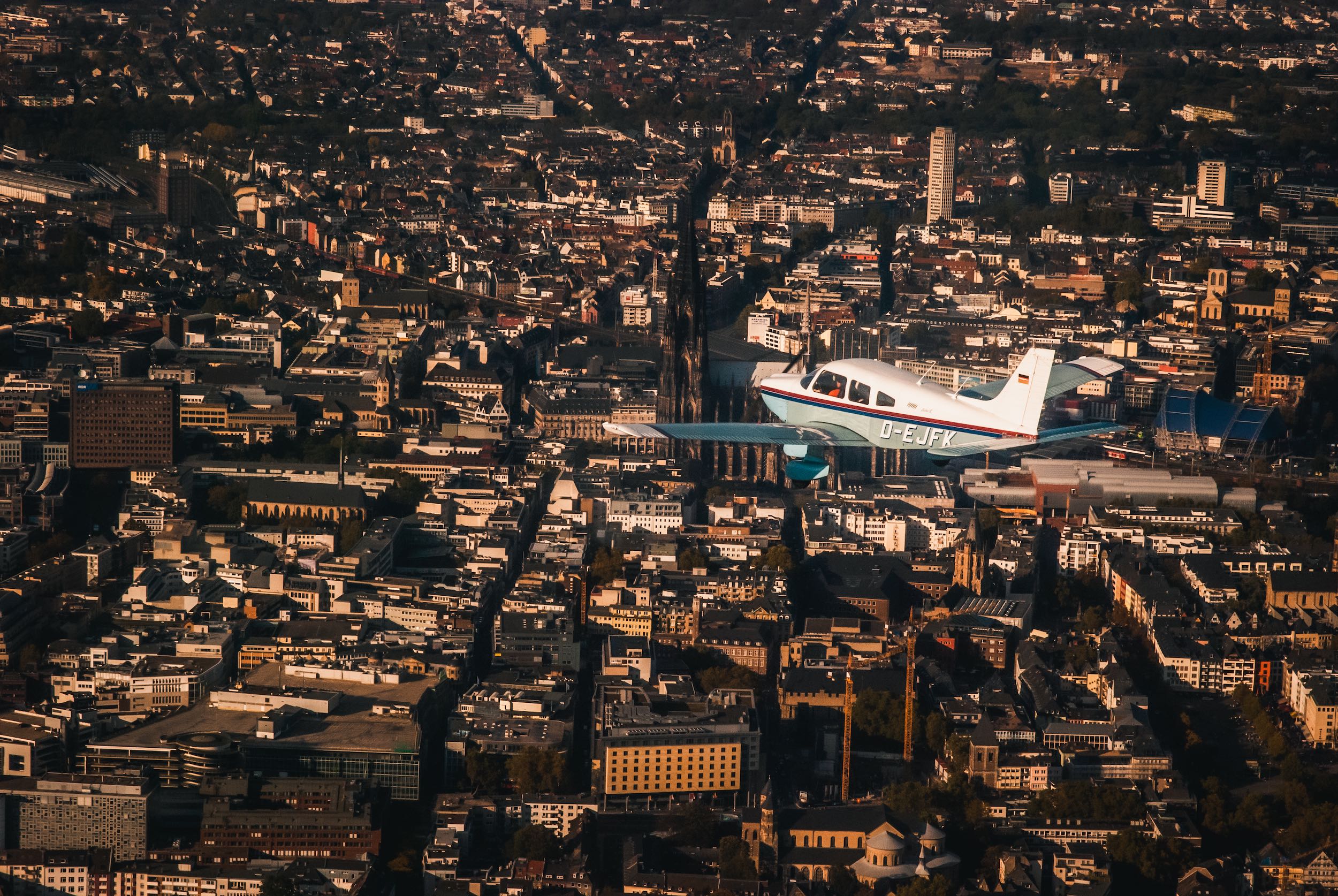 Vereinsflugzeug über Kölner Innenstand vor Dom